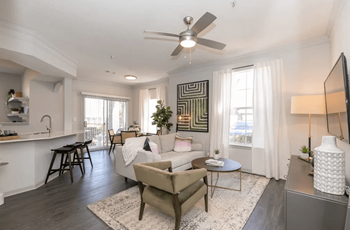A living room with a white couch and a ceiling fan.